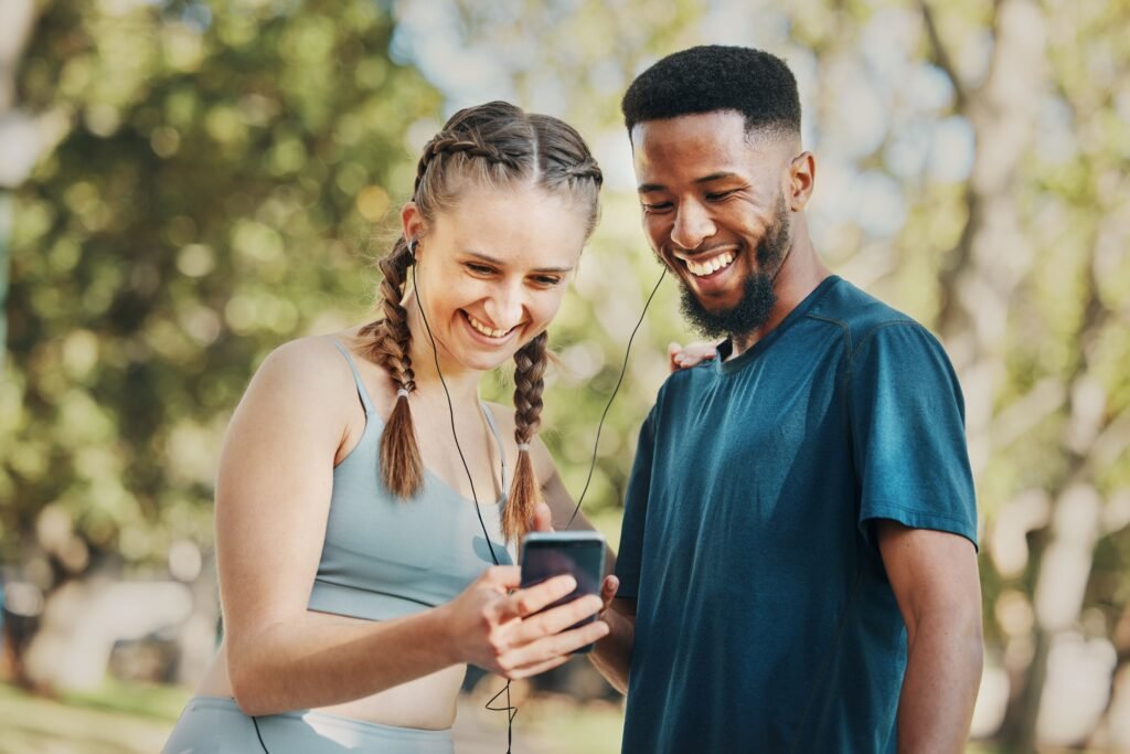 Phone, music and fitness with a diversity couple streaming audio while running in the park for exer