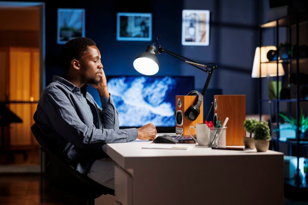 African american guy yawning while working at home