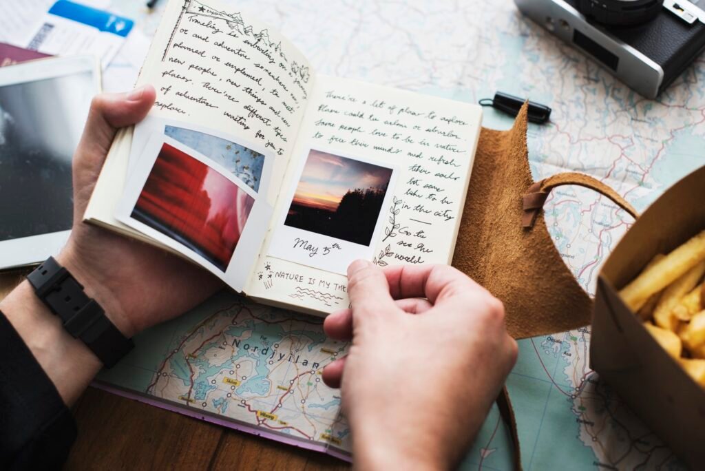 Closeup of hands holding journey diary notebook over map backgro
