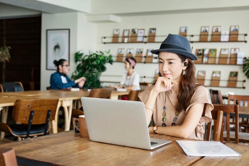 Group of young Japanese professionals working on laptop computers in a co-working space.