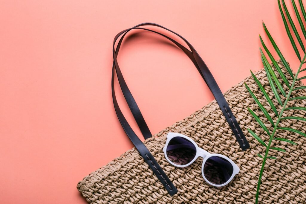 Stylish straw bag and sunglasses. Concept of summer holidays
