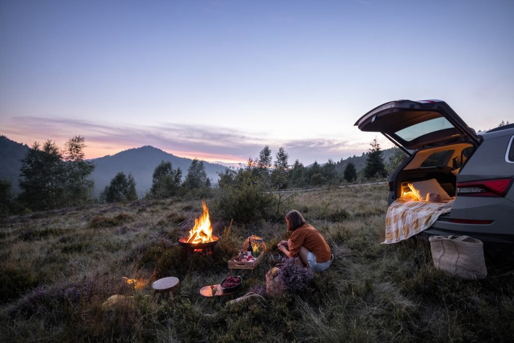 Woman traveling by car and having a picnic in the mountains