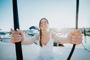 Young woman enjoying summer vacation next to her yacht.luxurious yacht cruise, sea travel