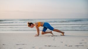 Young woman taking exercises at beach, morning routine and healthy lifestyle concept.