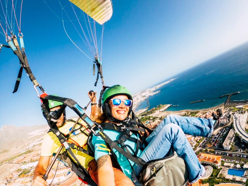 Cheerful happy woman to paraglyde experience with pilot