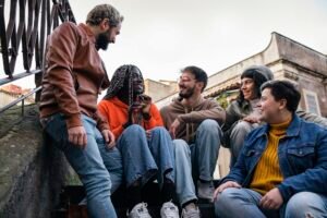 Multiracial best friends talking together sitting outdoors