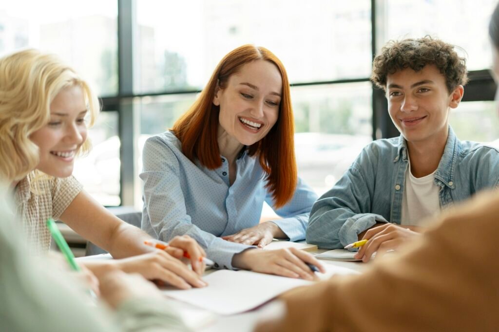 Smiling female teacher having lesson, studying, learning language with school children in classroom