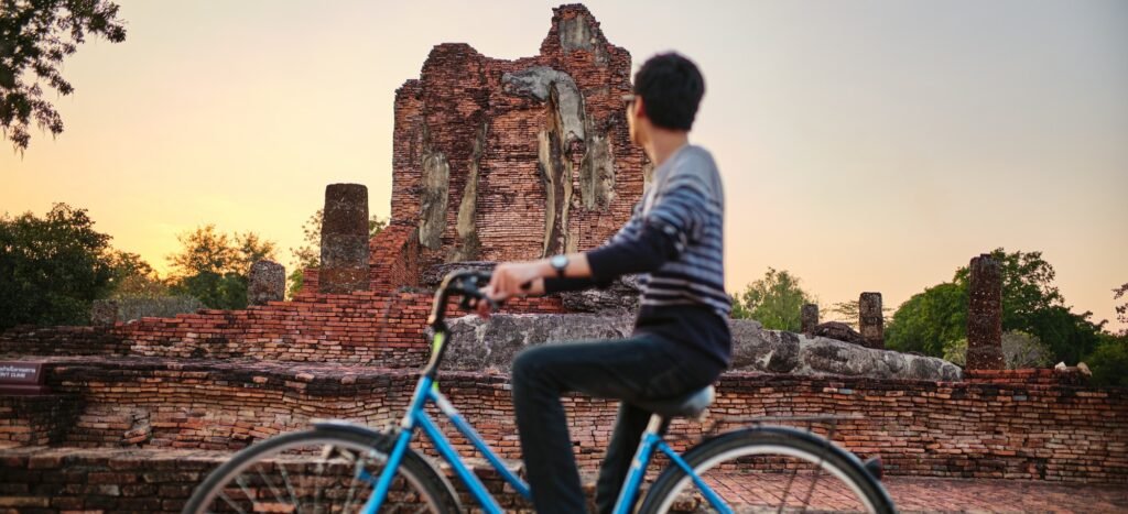 solo male thai tourist on bike visiting sukhothai historical park in thailand