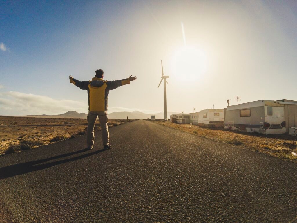 Standing man in the middle of the road opening arms for happy travel concept