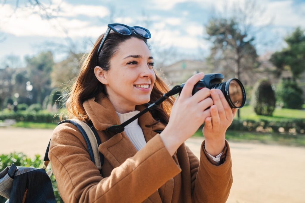 young female photographer smiling and shooting a artistic photo on a weekend travel activity. One