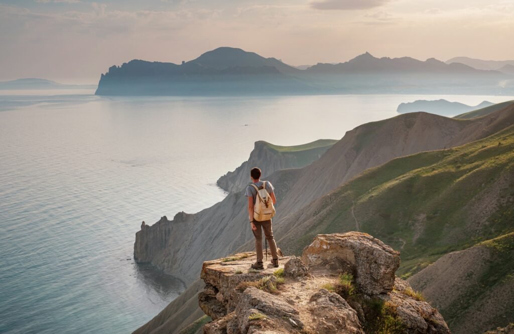 Young man travels alone on the backdrop of the mountains