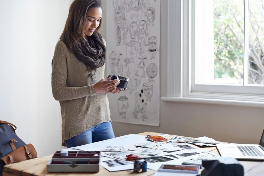 Checking her lens. A young woman working on her portfolio at home.