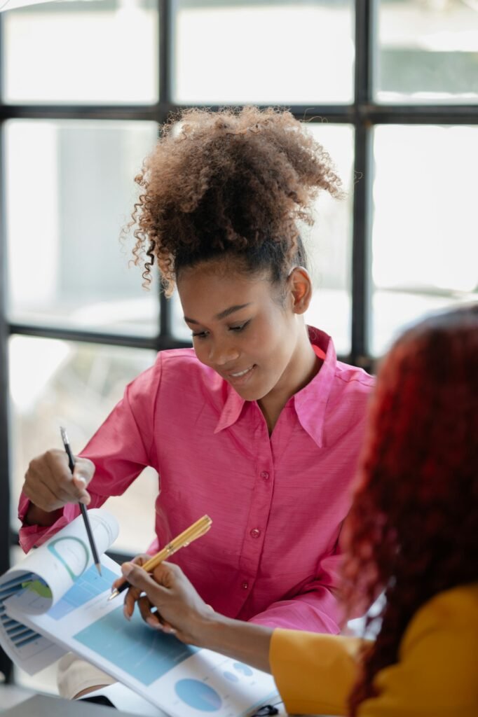 Two beautiful successful African business woman are discussing future business ventures together at