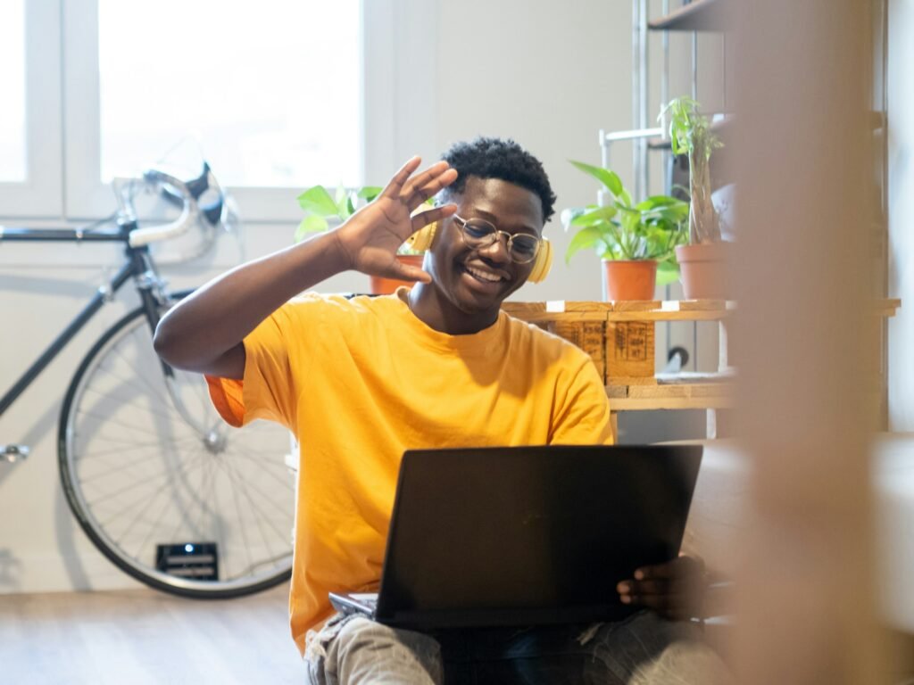 Young african american man making a video call with a laptop in a apartment