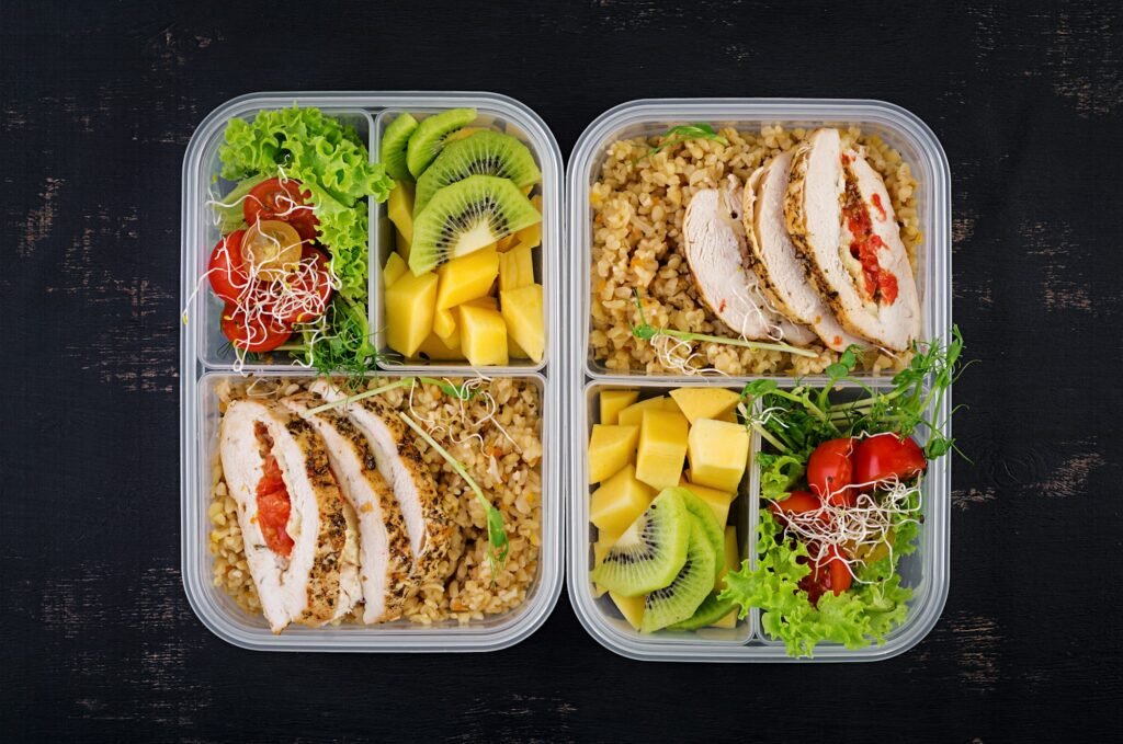 Lunch box chicken, bulgur, microgreens, tomato and fruit. Healthy fitness food.