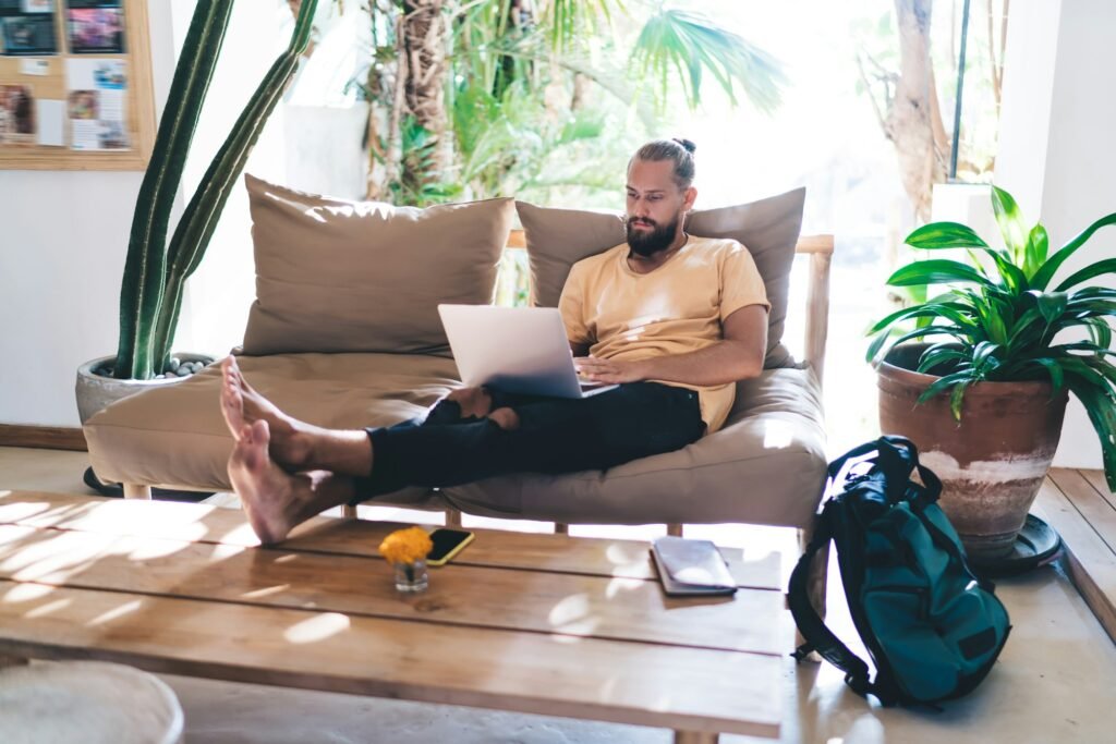 Skilled male digital nomad doing distance job on laptop computer using 4g wireless internet at terra