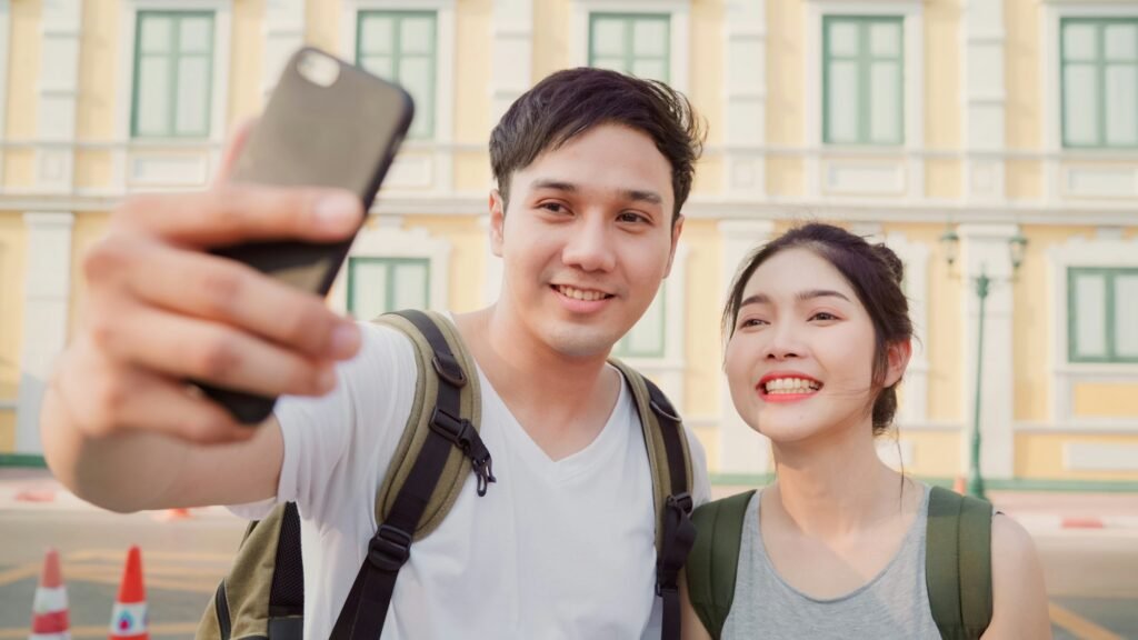 Asian blogger couple travel in Bangkok, Thailand, sweet couple using mobile phone make vlog.