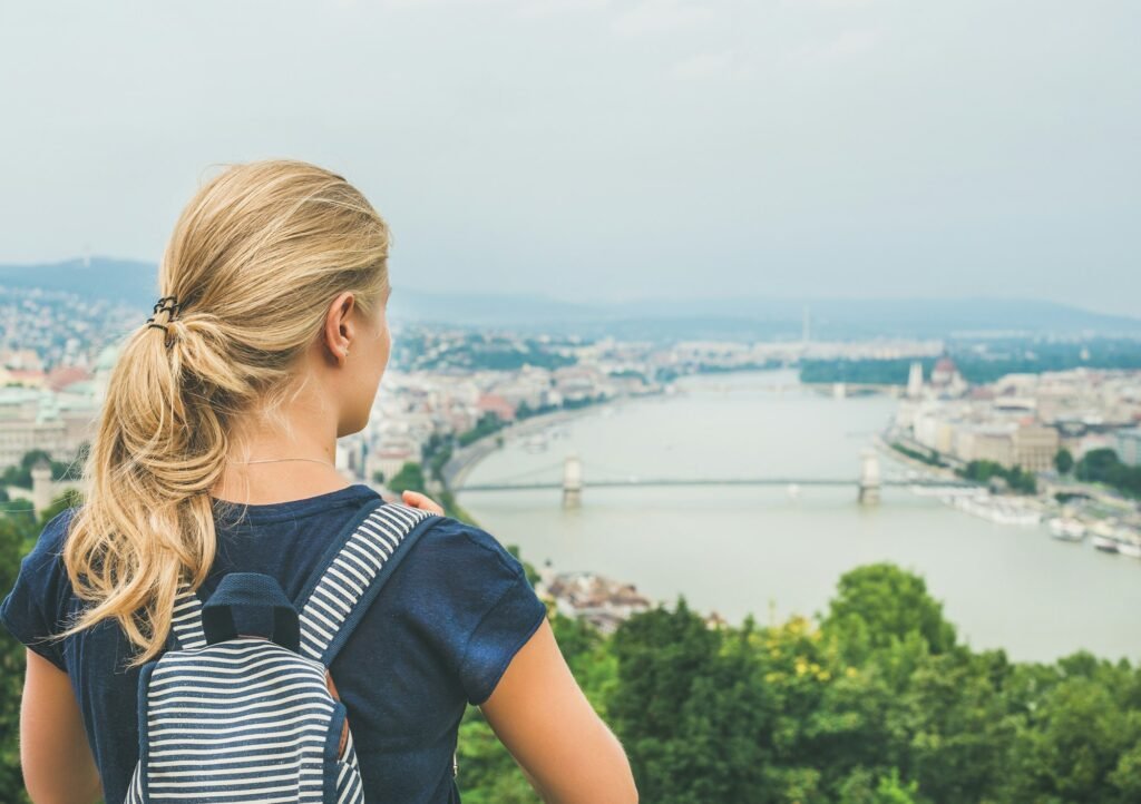 Young woman traveler looking at Danube river, Budapest, Hungary