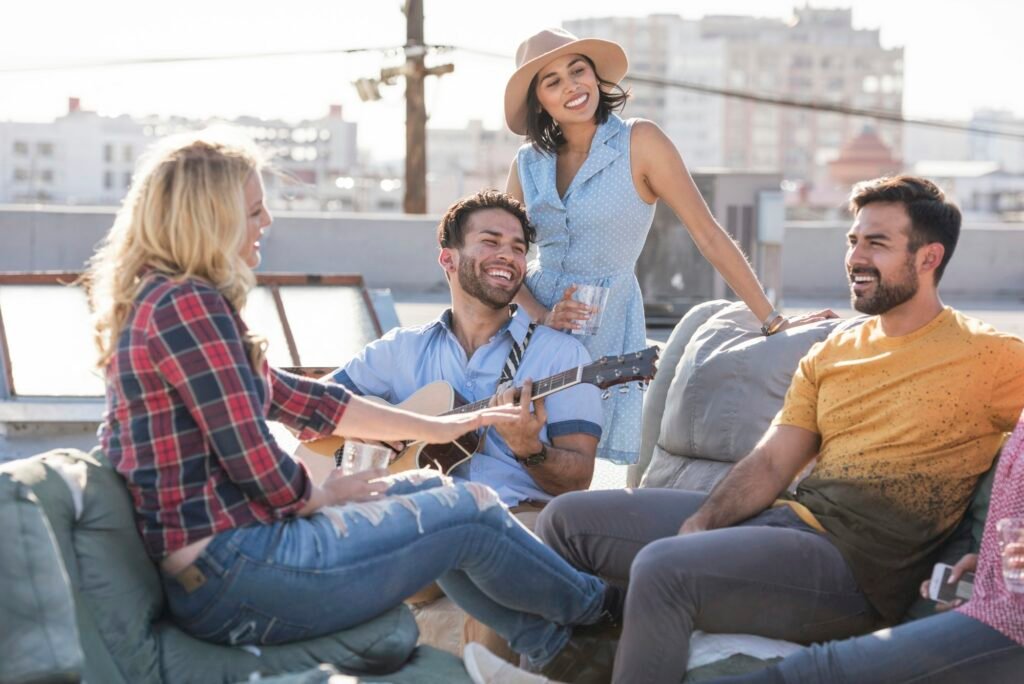 Friends having a rooftop party and playing guitar