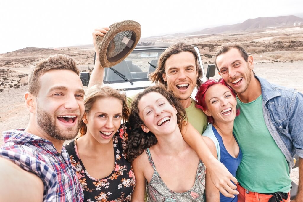 Group of travel friends taking selfie in the desert during a roadtrip