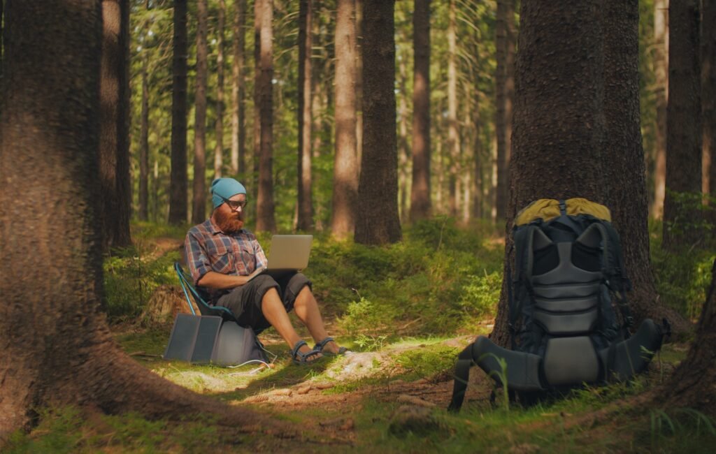 man using a laptop outdoors during a camping trip, digital nomad, work on the road